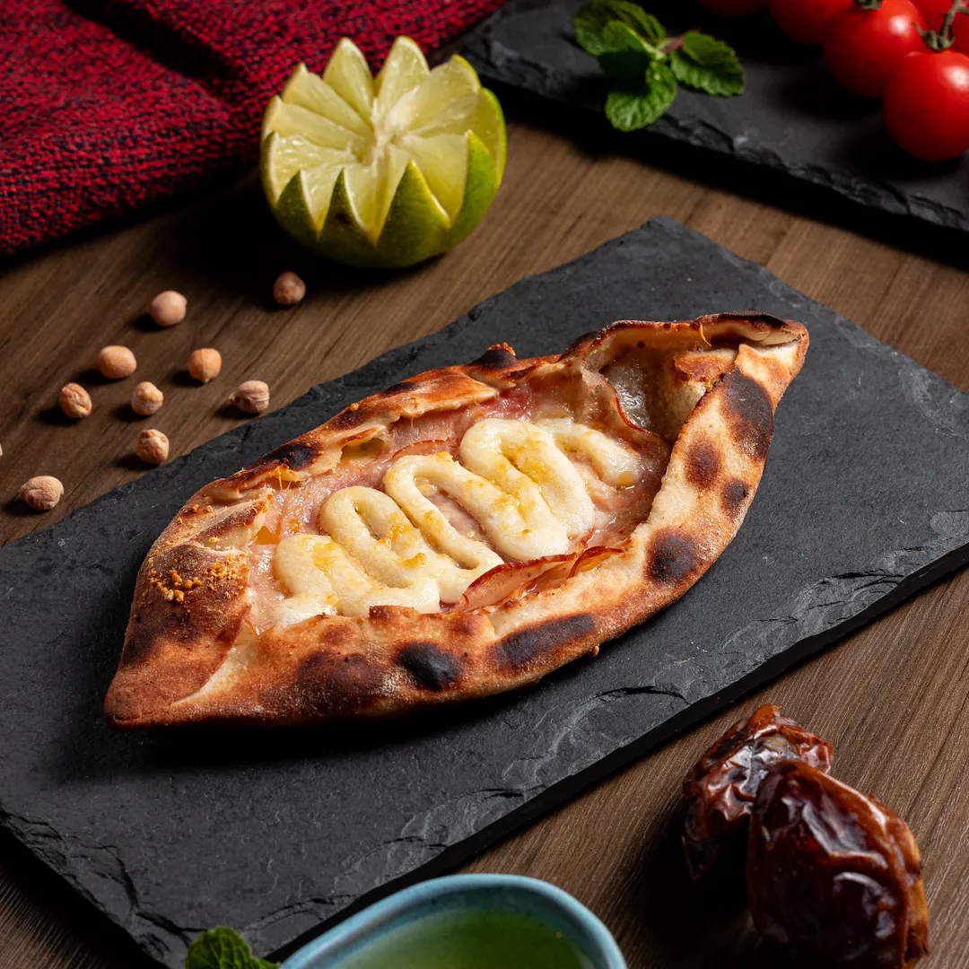 Esfiha especial assada com queijo sobre uma pedra de servir