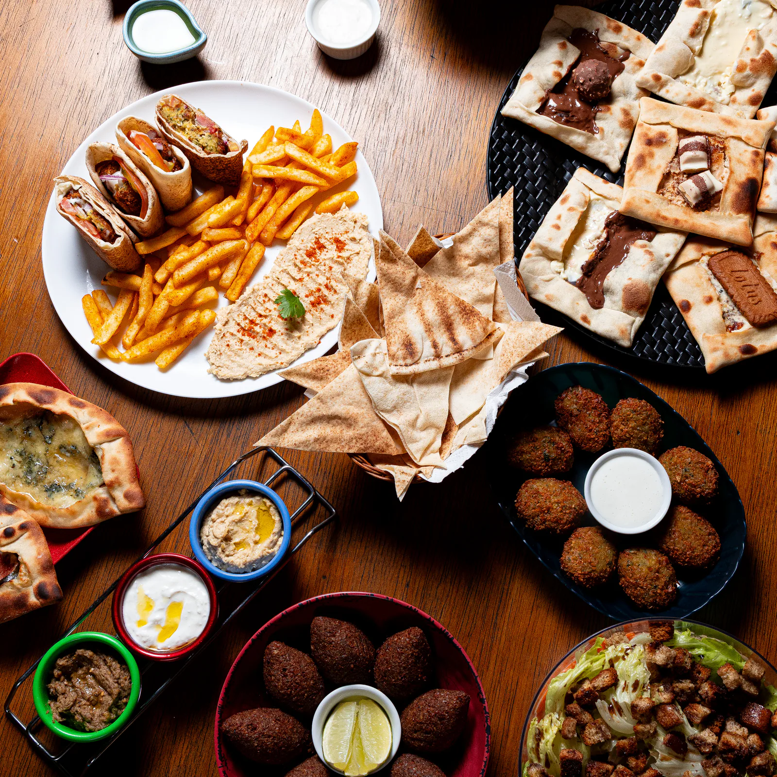 Mesa com esfihas, shawarmas, pastas, batatas e falafel da Sabbag