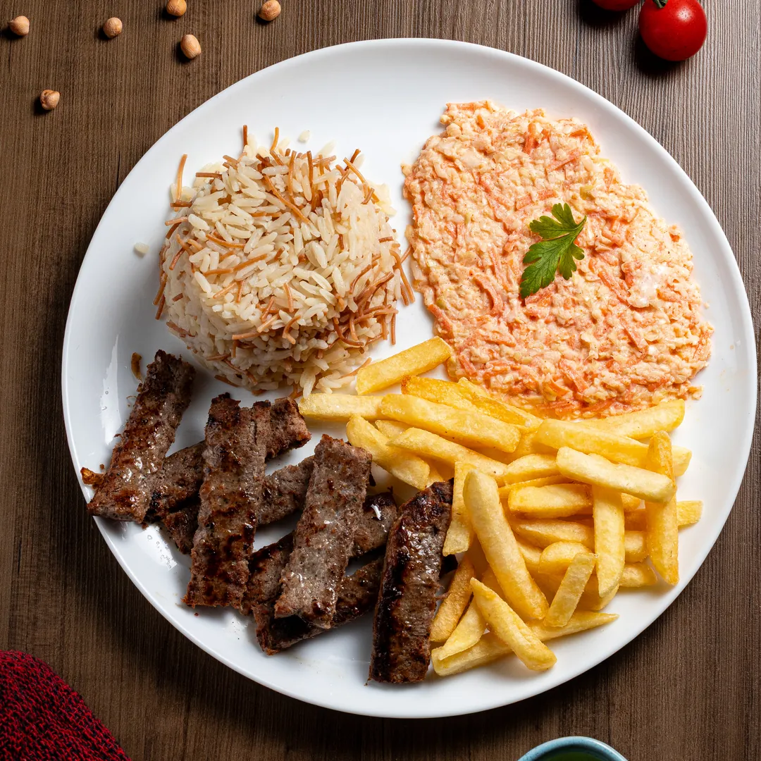 Prato árabe com arroz, carne grelhada, salada e batatas